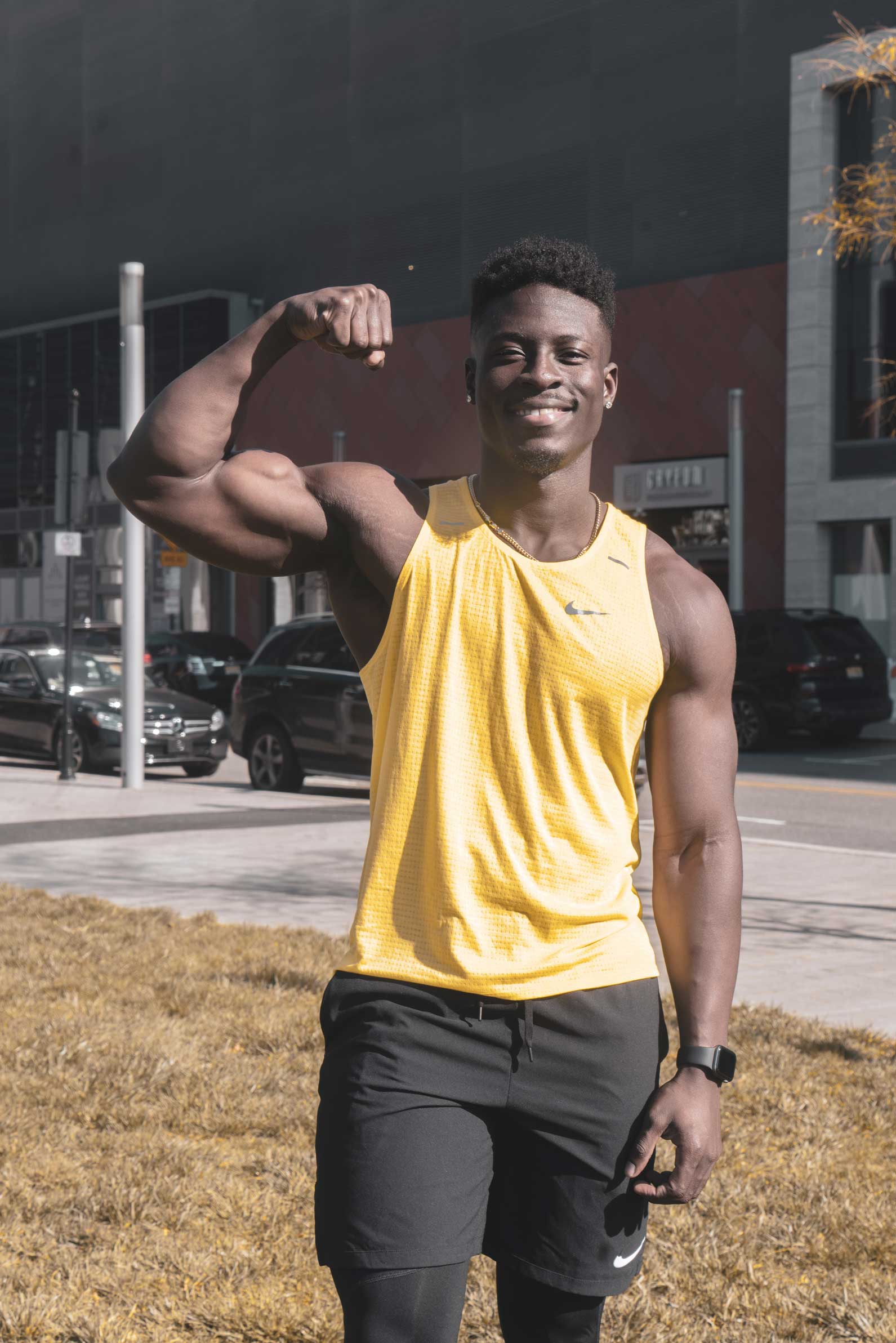 Image of HF wearing a yellow vest while flexing bicep